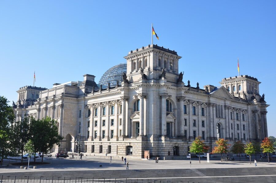 The Reichstag building in Berlin, Germany, with its impressive dome and historical significance, under a clear sky.