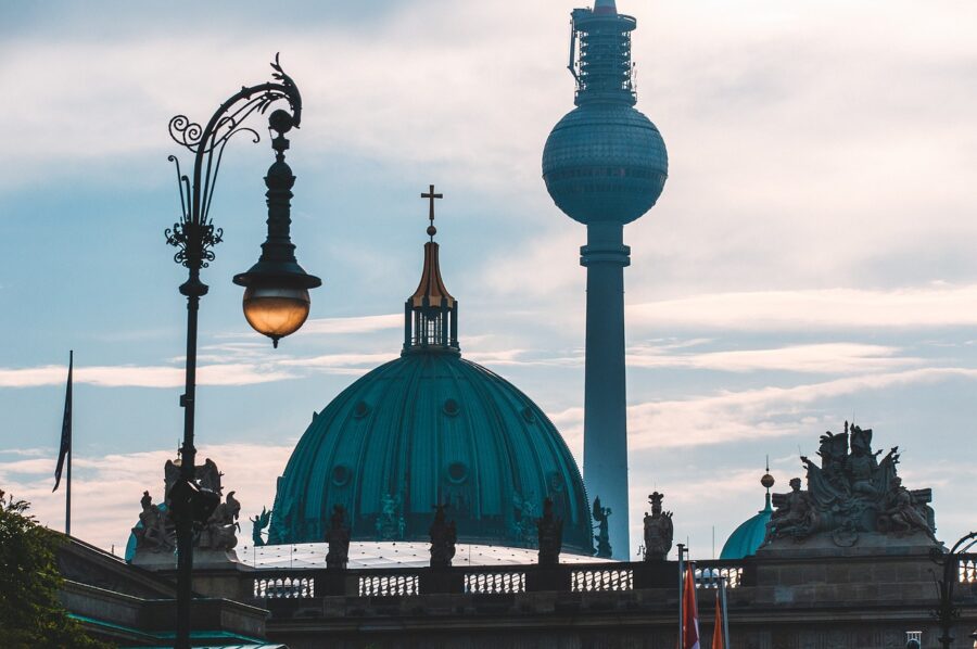 The Berlin Television Tower (Fernsehturm) in Germany, standing tall against a clear blue sky, with its distinctive spherical observation deck.