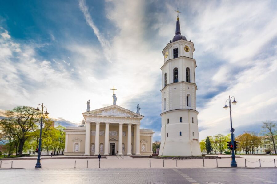 Vilnius Cathedral and Cathedral Square, featuring the iconic white cathedral and bell tower under a cloudy sky.