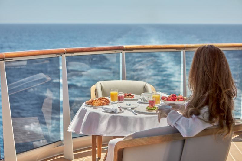 Explora 1 Luxury Cruise Ship - Ocean Terrace Experience: A passenger savors a delicious breakfast while overlooking the vast ocean