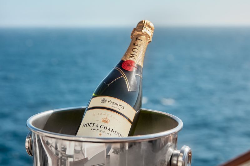 Chilled bottle of Moët & Chandon champagne in an ice bucket aboard Explora 1, with the stunning ocean as a backdrop