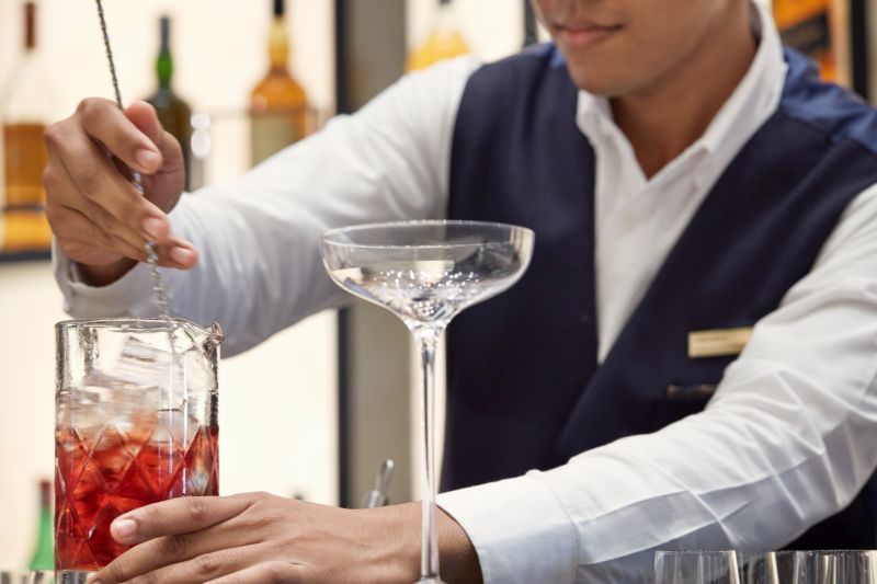 A skilled bartender prepares an elegant cocktail in the luxurious Lobby Bar.