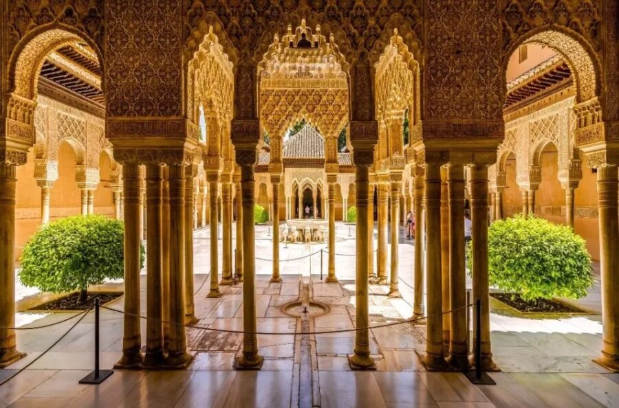 Exquisite Nasrid Palaces interior in Alhambra, Granada, Spain, showcasing intricate Moorish arches, ornate columns, and historical Islamic artistry.