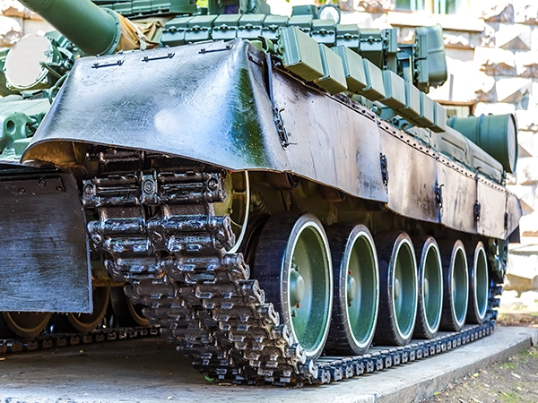 A close-up view of the complex track and wheel system of a WW2-era military tank.