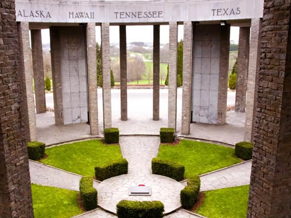 The interior courtyard and pillars of the Mardasson Memorial, showing the names of US states like Alaska, Hawaii, and Texas.