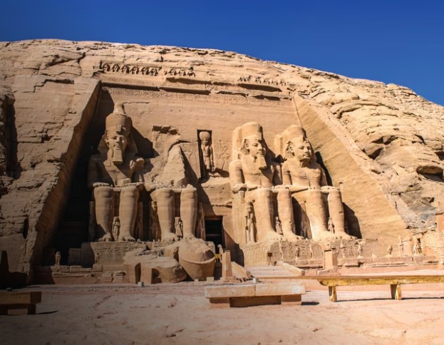 Colossal seated statues of Pharaoh Ramesses II carved into the cliff face on the majestic rock-cut facade of the Great Temple at Abu Simbel, Aswan, Egypt.