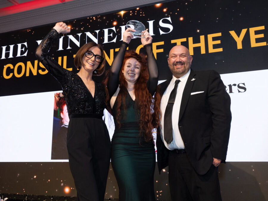 Travel Escapes consultant Chloe Broaders celebrating on stage and holding up her trophy for Travel Consultant of the Year 2025 at the ITTN Awards.