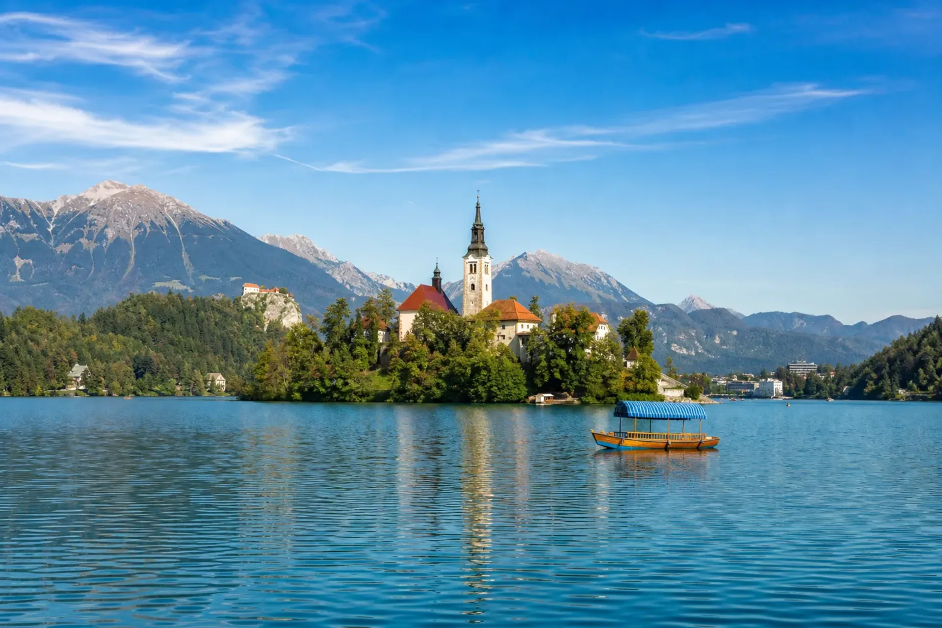 Slovenia-A sunny panoramic view of the island church at Lake Bled, a highlight of our Slovenia Gulf of Trieste escorted tour.
