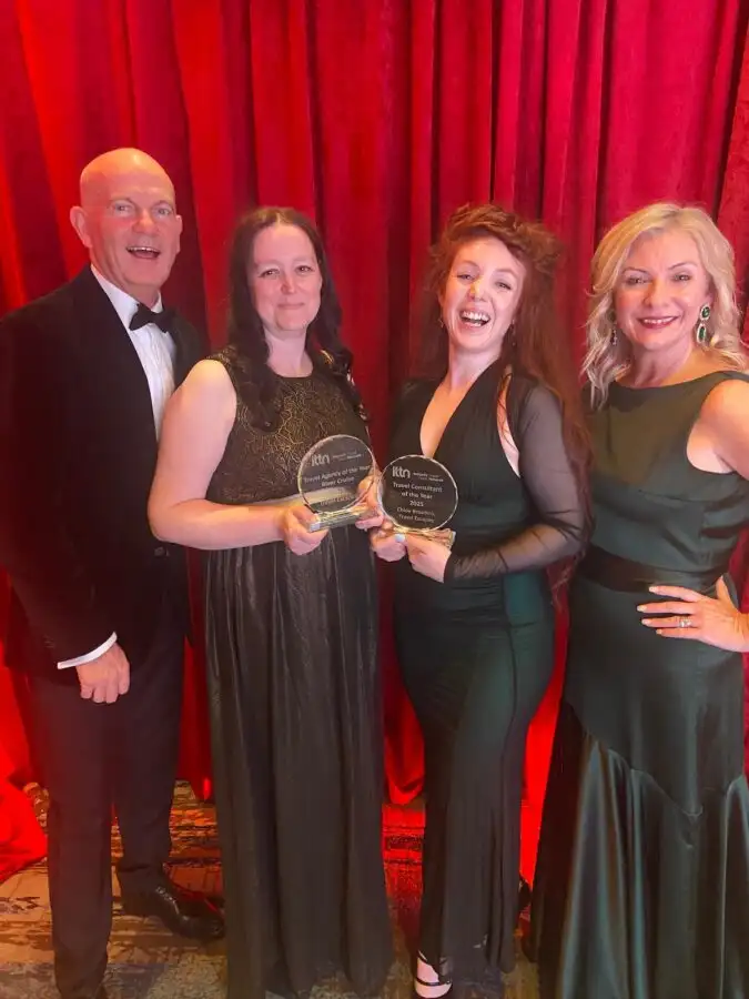 The Travel Escapes team, including Alan and Celine, smiling and showcasing their two trophies at the ITTN Awards 2025, celebrating wins for River Cruise Agency of the Year and Travel Consultant of the Year.