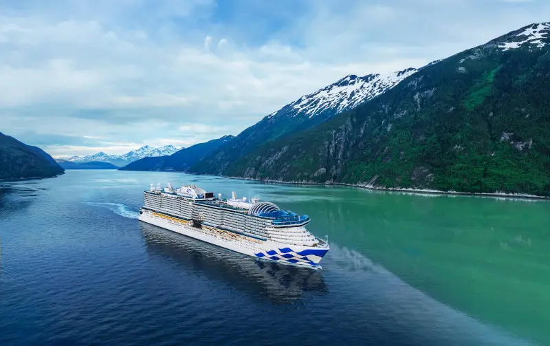 Star Princess cruise ship sailing through an Alaskan fjord near Skagway.