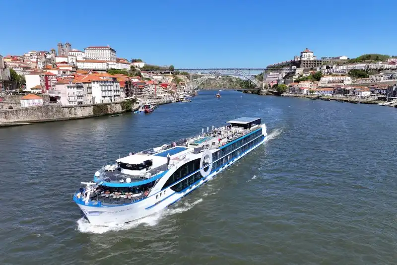 Aerial view of a contemporary Travelmarvel river cruise ship sailing past a historic European river town