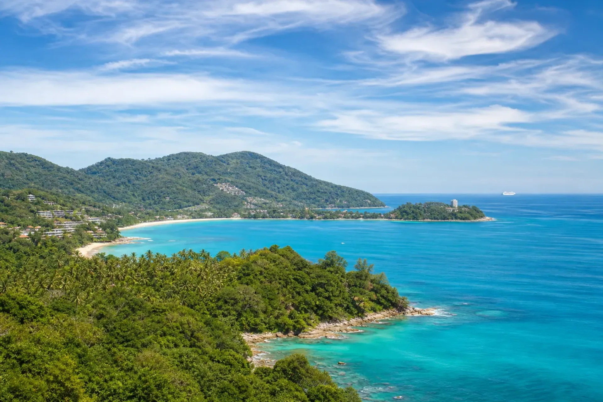 Asia-A bright coastal view of Phuket with a passenger ship on the horizon, part of a Singapore Penang Phuket cruise.
