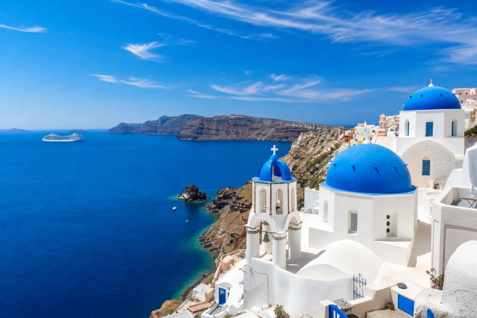 Greece & Croatia-A stunning sun-drenched view of Santorini's coastline, a highlight on your Greece Croatia cruise.