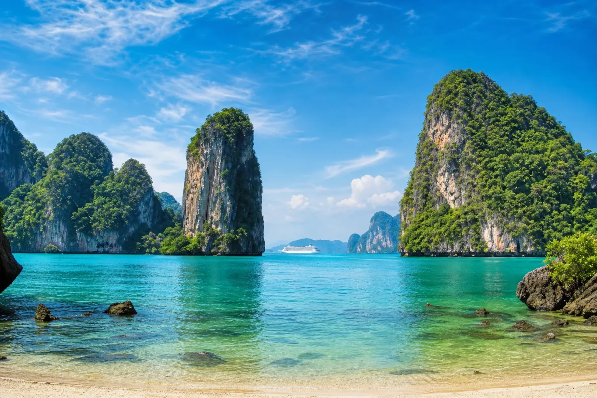 Malaysia & Thailand-A scenic view of a Malaysia Thailand tour destination with limestone cliffs and a cruise ship on the horizon.