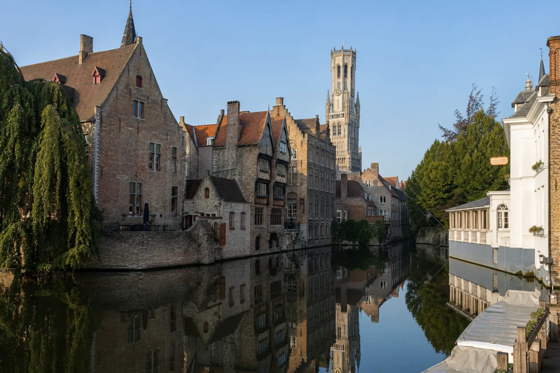 Belgium-A tranquil morning view of the historic canals in Bruges, perfect for a Bruges Ghent tour.
